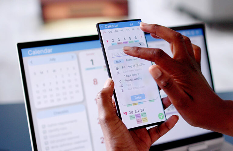 Hand holding mobile phone creating appointment on calendar