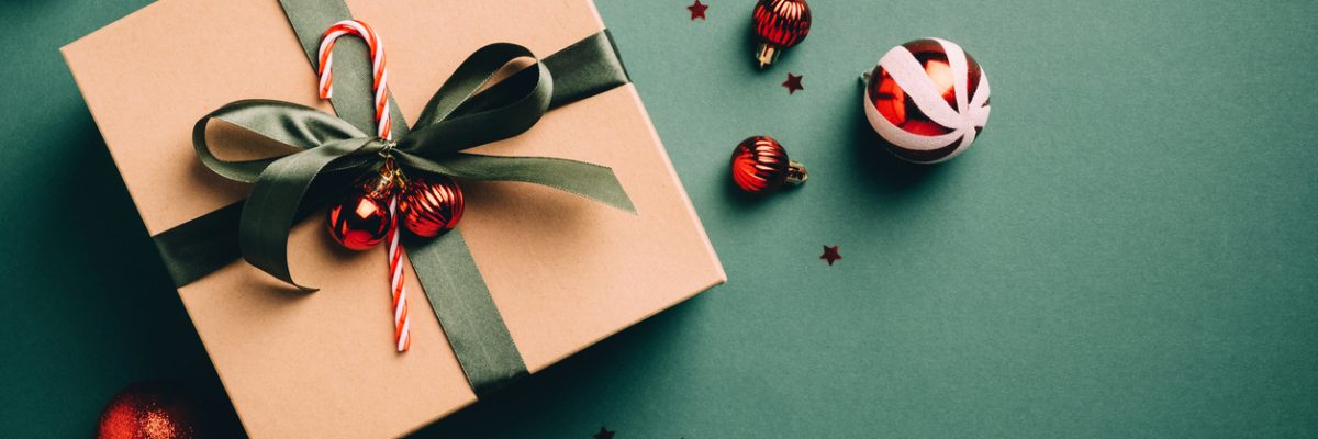 Vintage Christmas present and red balls on dark green background.